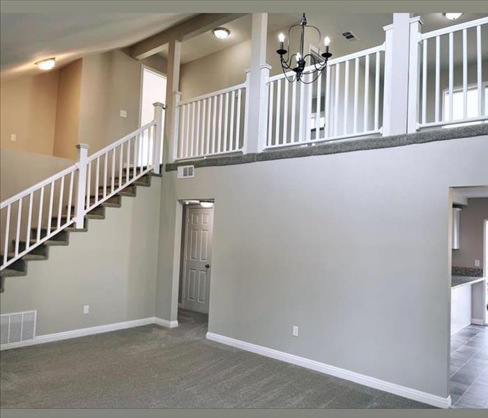 The interior of a two story home finished showing grey walls and beautiful stairs.