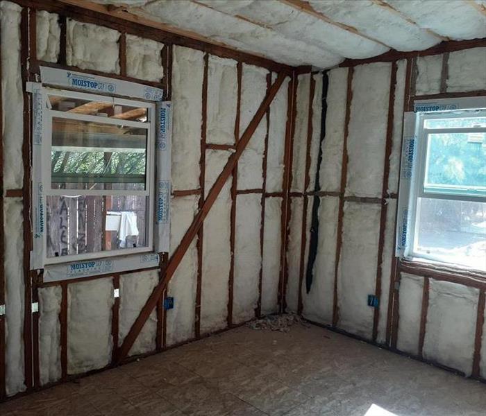 A open room with no drywall showing the insulation and framing. 